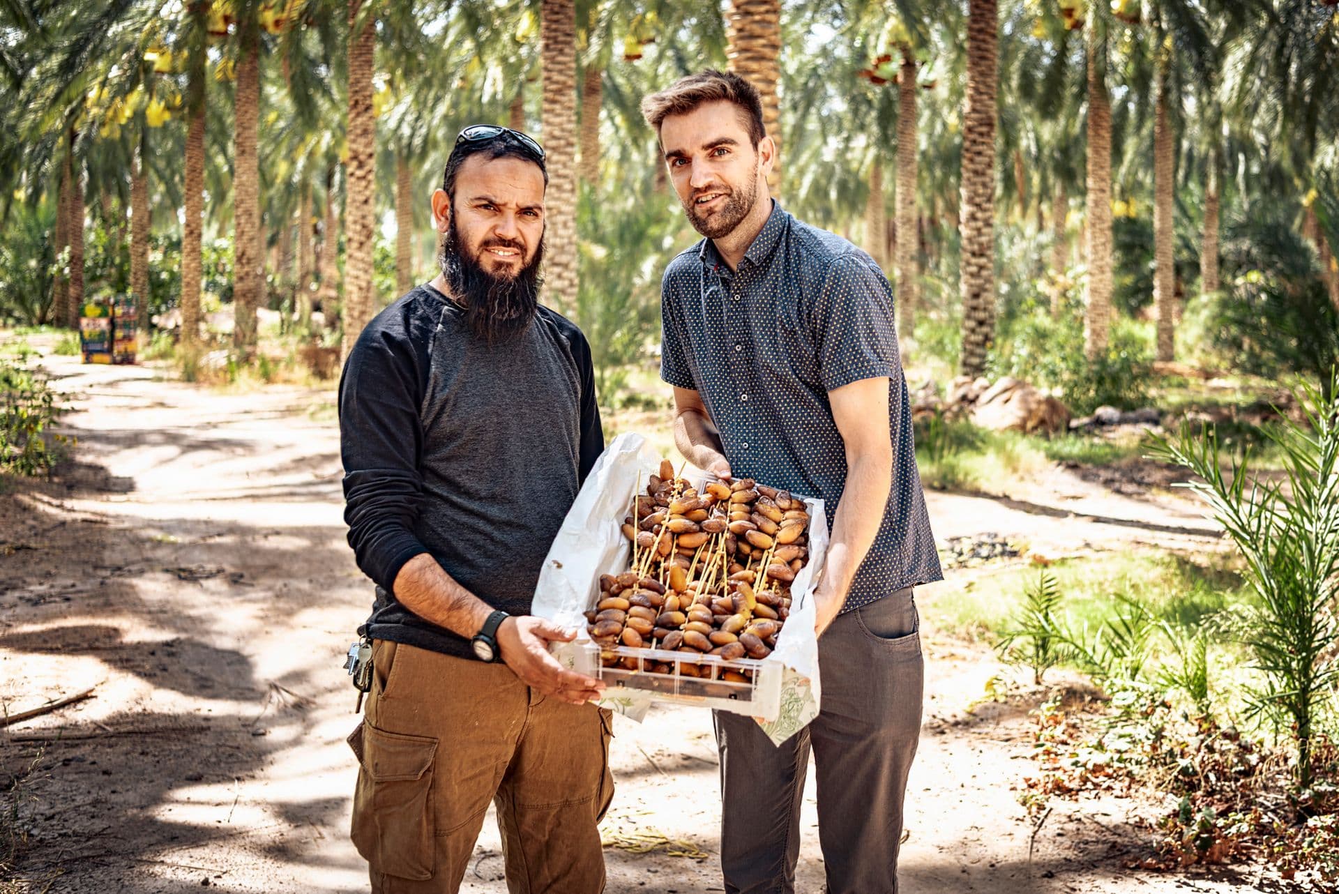 Gründer und Produzent mit einer Kiste frisch geernteter Datteln